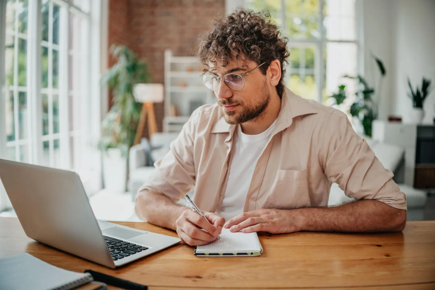 Un professionnel prend des notes devant son ordinateur portable